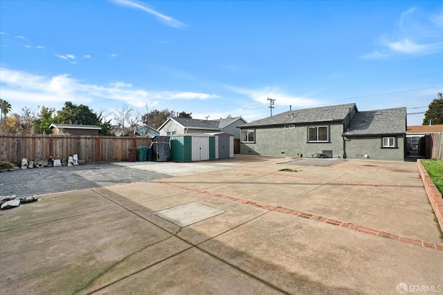 back of property with a patio and a shed