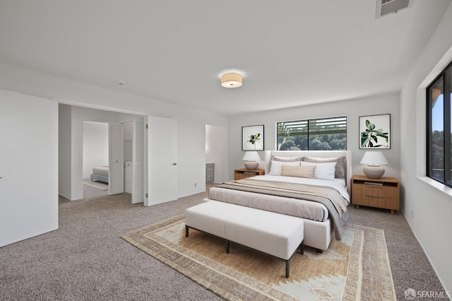 carpeted bedroom featuring visible vents and connected bathroom