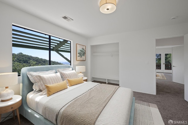 bedroom with a closet, visible vents, and carpet floors