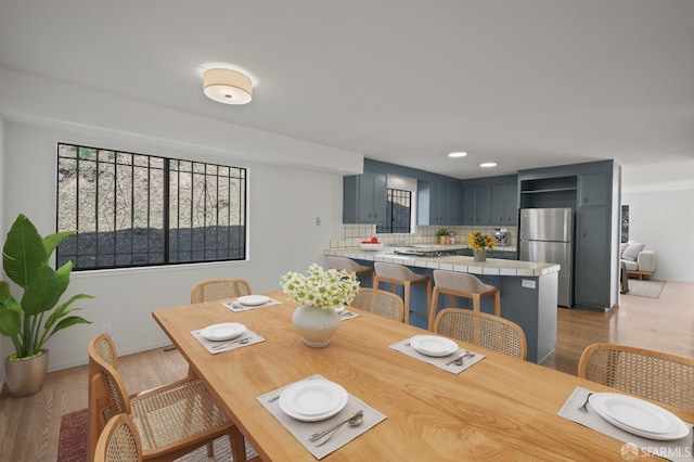 dining room featuring plenty of natural light, baseboards, and light wood finished floors