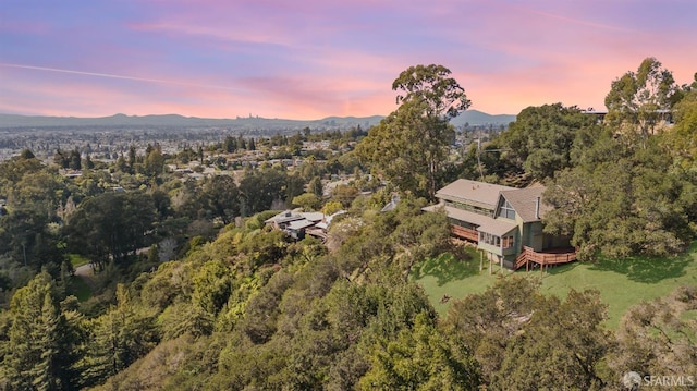 aerial view at dusk with a wooded view and a mountain view