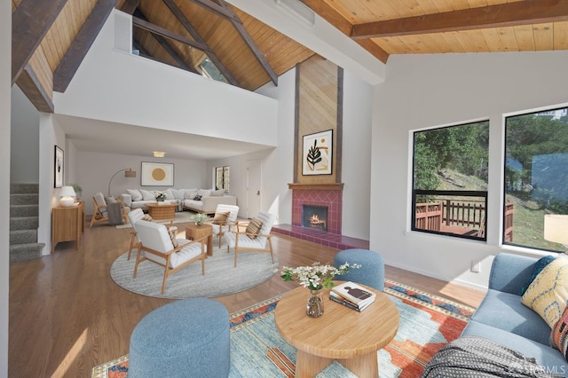 living room featuring wooden ceiling, a brick fireplace, wood finished floors, and stairs