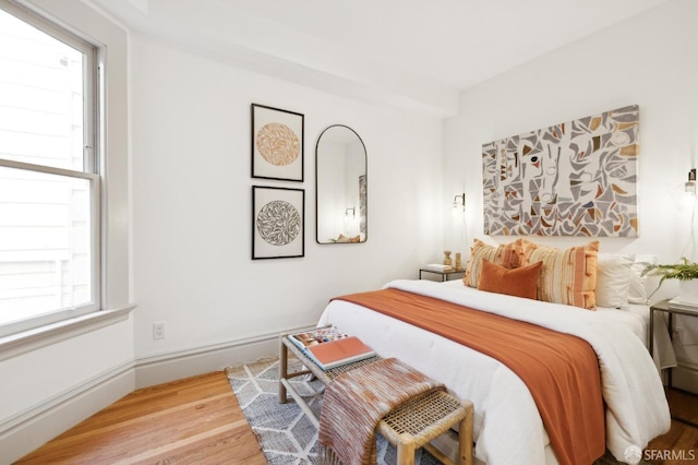 bedroom featuring hardwood / wood-style floors and multiple windows