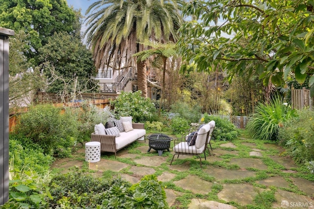 view of yard featuring an outdoor living space with a fire pit and fence