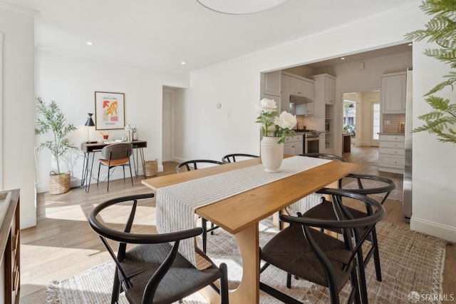 dining space with light wood finished floors, baseboards, ornamental molding, and recessed lighting