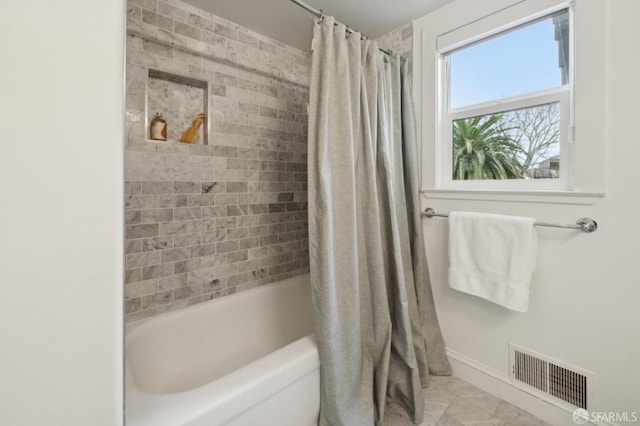 bathroom featuring shower / tub combo, visible vents, and baseboards