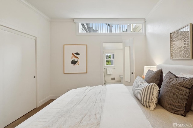 bedroom with ensuite bathroom and crown molding