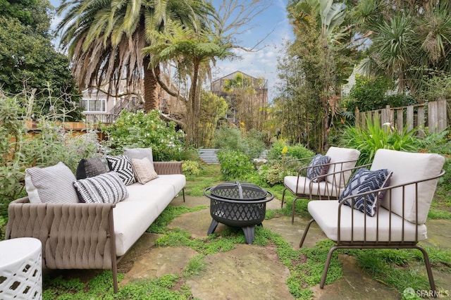 view of patio / terrace featuring an outdoor living space with a fire pit and fence