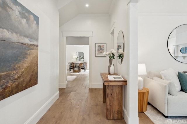 hallway with crown molding, baseboards, and wood finished floors