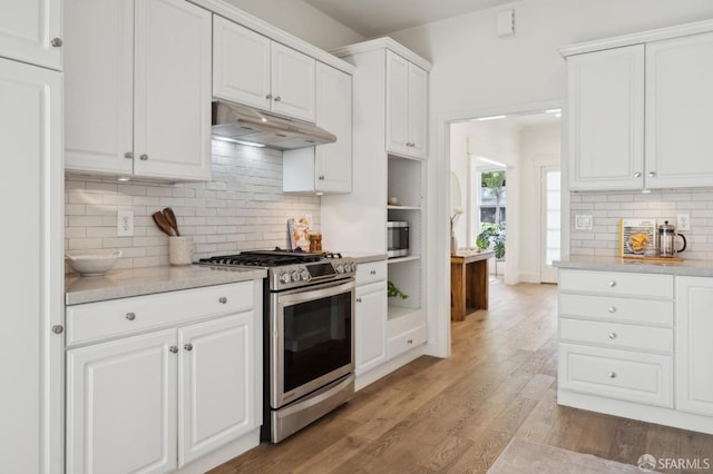 kitchen featuring tasteful backsplash, light wood-style flooring, stainless steel appliances, under cabinet range hood, and white cabinetry