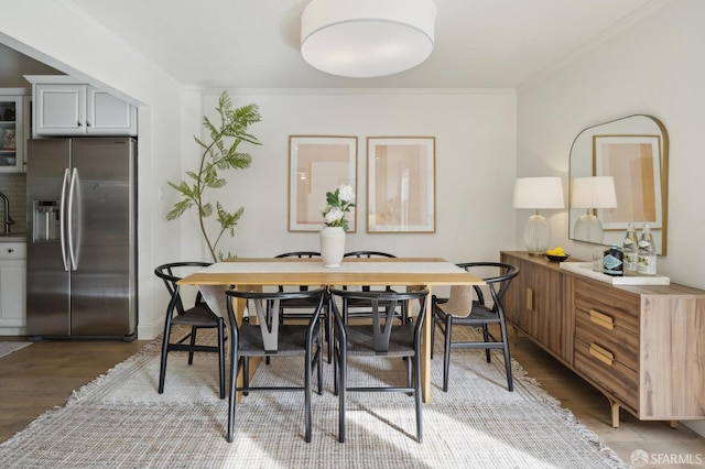 dining area with light wood-type flooring and crown molding