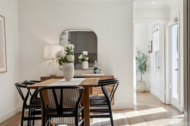 dining area with baseboards and crown molding