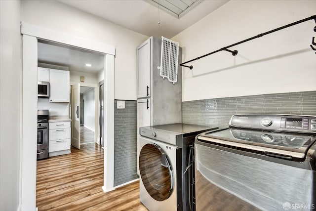 2830 Parker Ave, Oakland, CA 94605 - washroom featuring washing machine and clothes dryer, light wood-style floors, and attic access