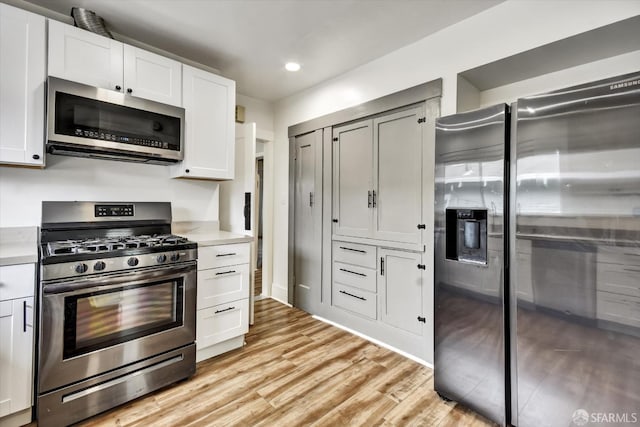 2830 Parker Ave, Oakland, CA 94605 - kitchen featuring stainless steel appliances, light countertops, light wood-style floors, recessed lighting, and white cabinets