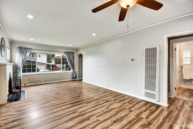 2830 Parker Ave, Oakland, CA 94605 - unfurnished living room featuring a heating unit, arched walkways, ornamental molding, healthy amount of natural light, and wood finished floors
