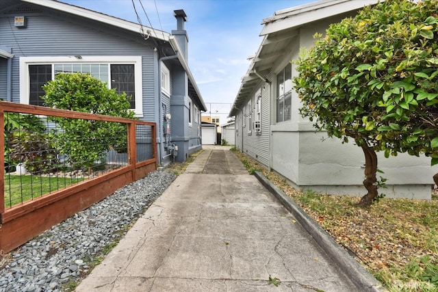2830 Parker Ave, Oakland, CA 94605 - view of side of property featuring a garage, a chimney, and concrete driveway