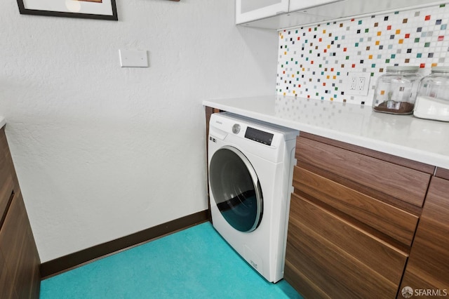clothes washing area with washer / dryer, carpet flooring, and baseboards