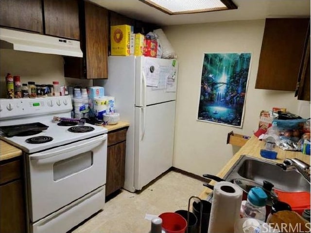 kitchen with white appliances, dark brown cabinets, and sink