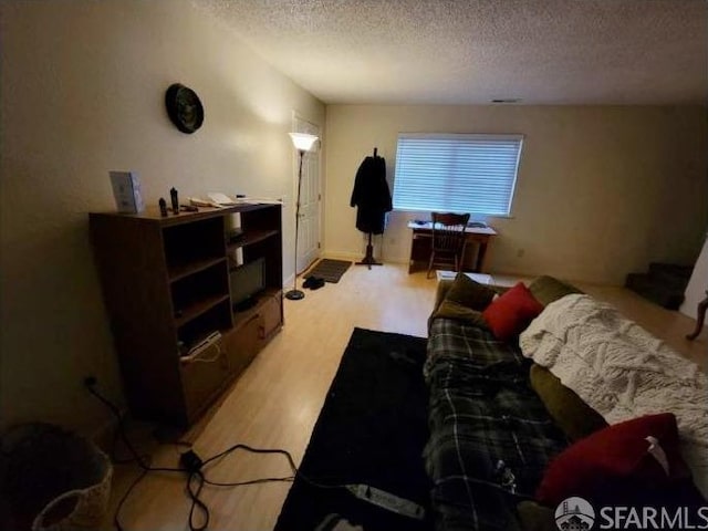 bedroom with light hardwood / wood-style floors and a textured ceiling