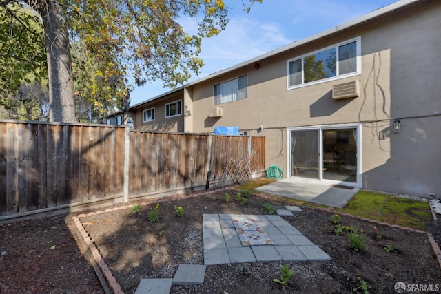 rear view of property featuring a wall mounted air conditioner and a patio area