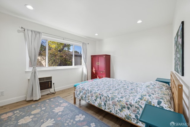 bedroom featuring a wall mounted AC and hardwood / wood-style floors