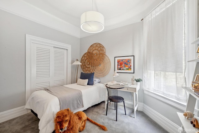 carpeted bedroom featuring a closet and baseboards