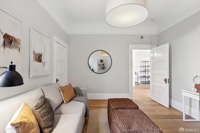 living area featuring light wood finished floors, visible vents, and baseboards