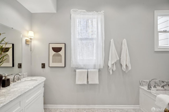 bathroom featuring a bath, vanity, and baseboards