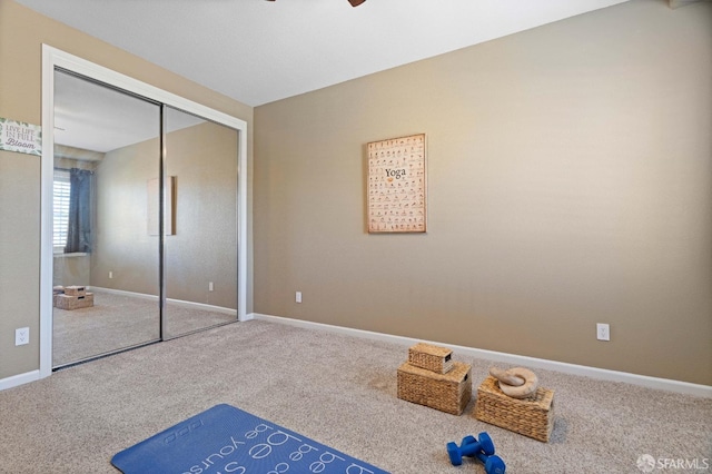unfurnished bedroom featuring carpet floors, a closet, a ceiling fan, and baseboards