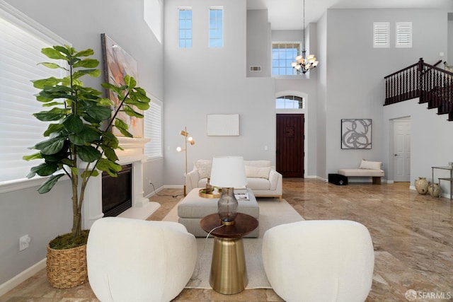 living room featuring a chandelier, stairway, a high ceiling, and visible vents