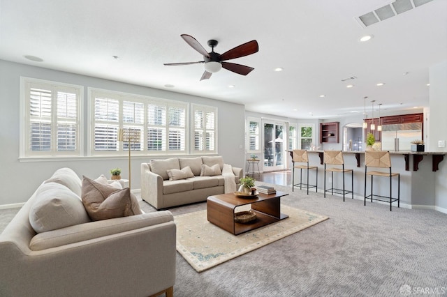 living area with ceiling fan, light carpet, baseboards, visible vents, and recessed lighting