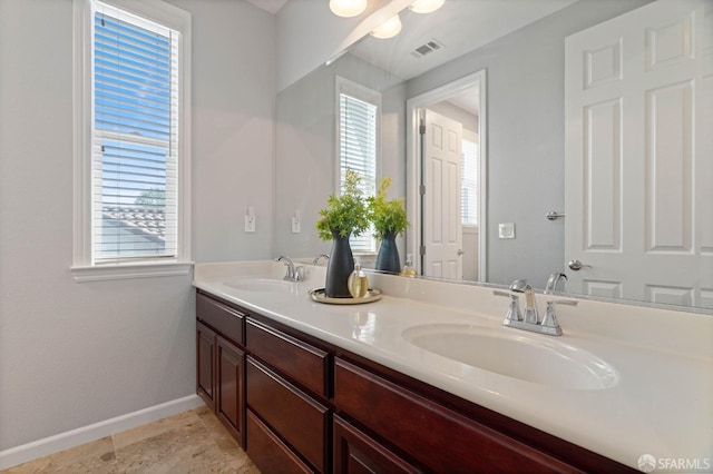 full bathroom with visible vents, baseboards, a wealth of natural light, and a sink