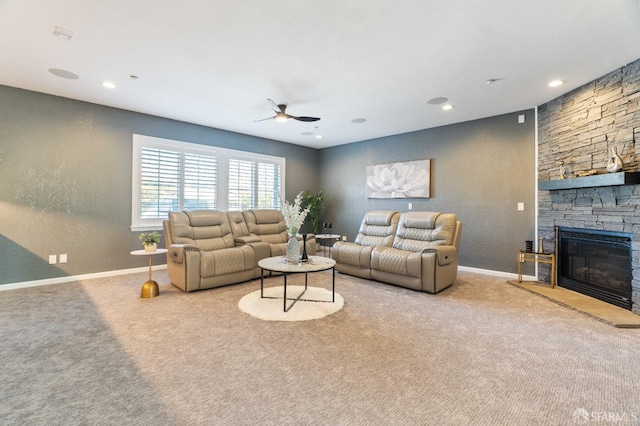 living area with a fireplace, baseboards, carpet floors, and ceiling fan