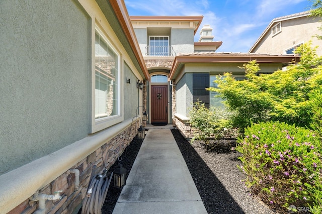 entrance to property with stone siding and stucco siding
