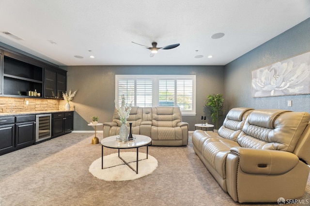 living area with beverage cooler, bar area, ceiling fan, light carpet, and visible vents