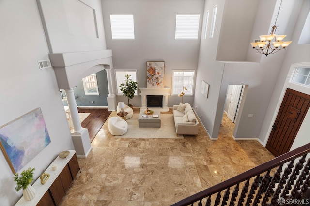 foyer with a high ceiling, a healthy amount of sunlight, visible vents, and an inviting chandelier