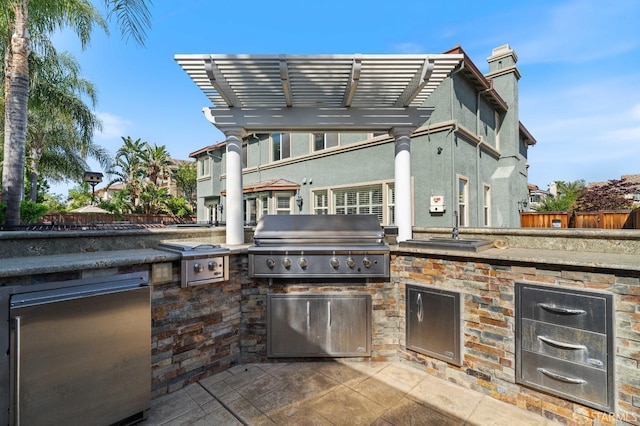 view of patio featuring an outdoor kitchen, a sink, a grill, and fence