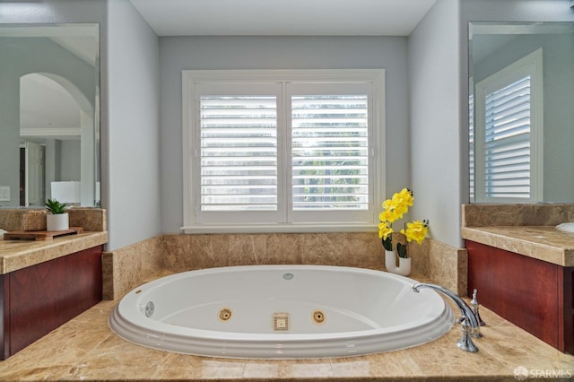 bathroom with a jetted tub and vanity