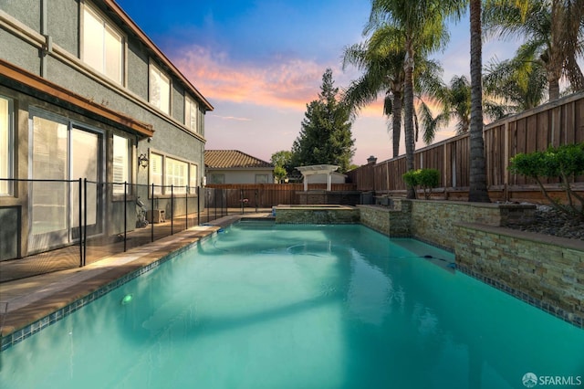 view of pool with a pool with connected hot tub and a fenced backyard