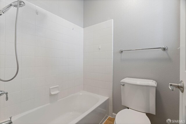 bathroom featuring shower / bathtub combination and toilet