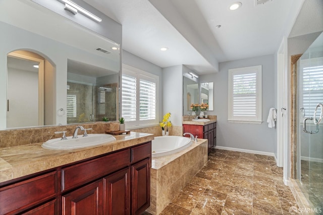 bathroom with a sink, a stall shower, a bath, two vanities, and visible vents