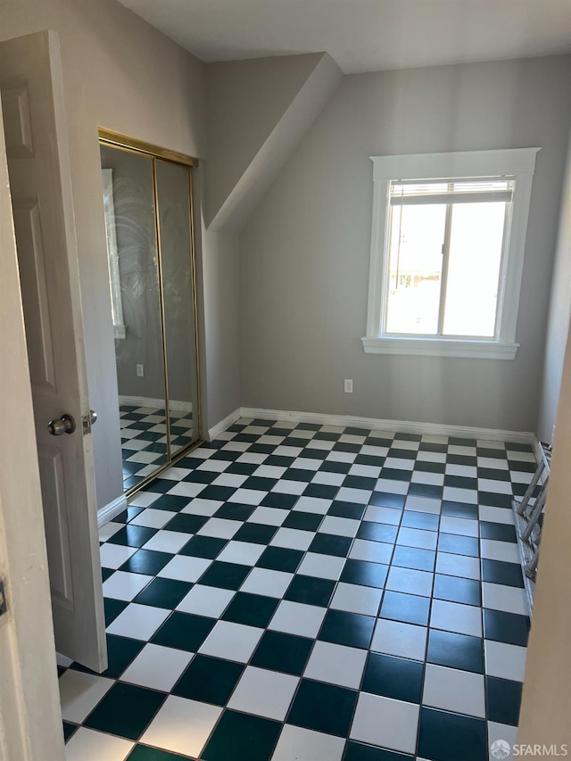 bonus room with tile patterned floors and baseboards