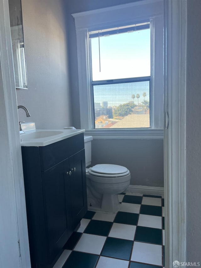 bathroom featuring tile patterned floors, baseboards, toilet, and vanity