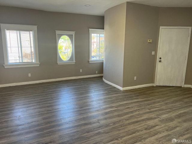 interior space featuring baseboards and dark wood finished floors