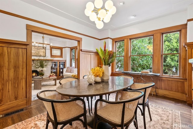 dining room featuring an inviting chandelier, hardwood / wood-style floors, and a fireplace