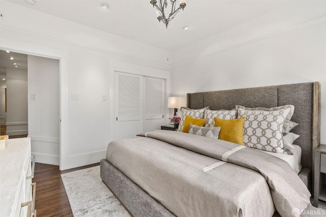 bedroom with dark wood-type flooring and a closet