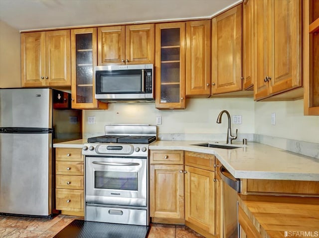 kitchen featuring light tile patterned flooring, stainless steel appliances, and sink