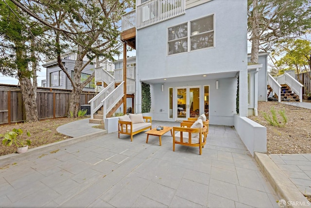 rear view of property featuring stucco siding, french doors, a patio area, and stairs