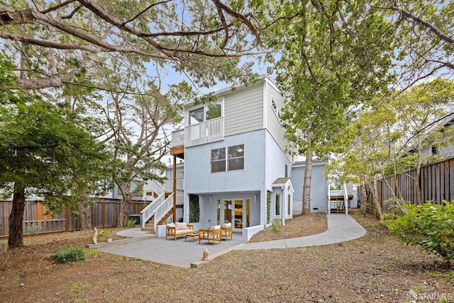 back of property featuring a patio, outdoor lounge area, a fenced backyard, and a balcony