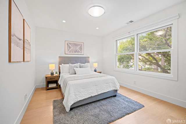 bedroom featuring light wood-type flooring, baseboards, visible vents, and recessed lighting